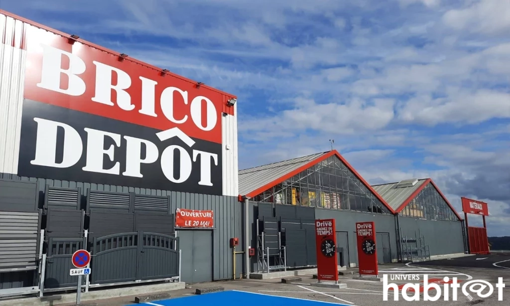 Photo en biais de a façade du magasin Brico Dépôt, permettant ainsi de voir sur la droite du bâtiment la partie drive et cour des matériaux.